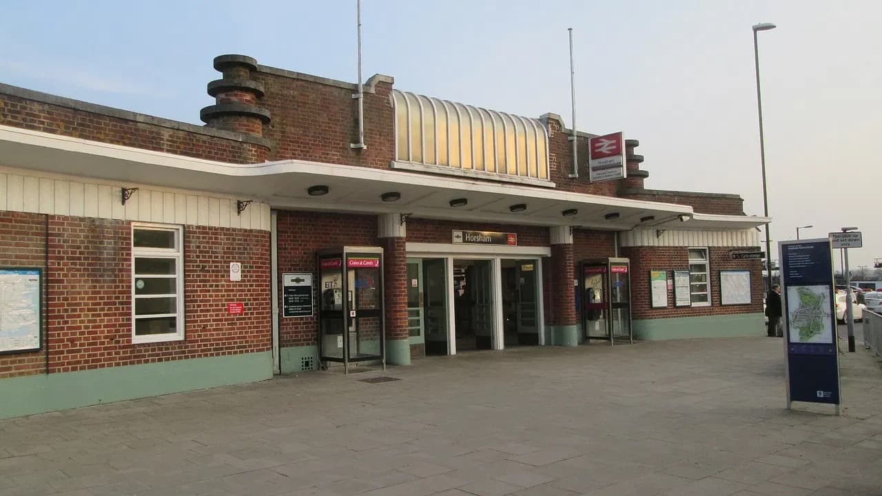 The brick front of Horsham railway station with the Horsham name sign above the entrance