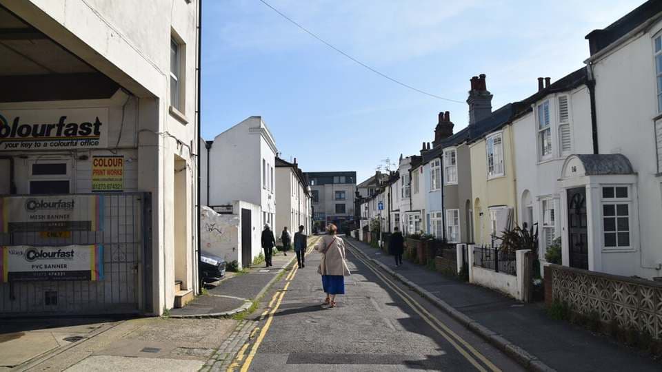Cheltenham Place in Brighton, a narrow street of white and pastel terraced houses with double yellow lines in the North Laine