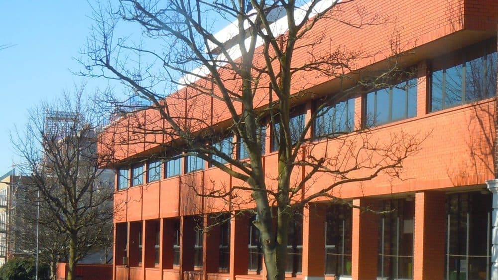 Preece House on Davigdor Road in Hove, a red brick office building with bare trees in front of it, next to the site of the planned office
