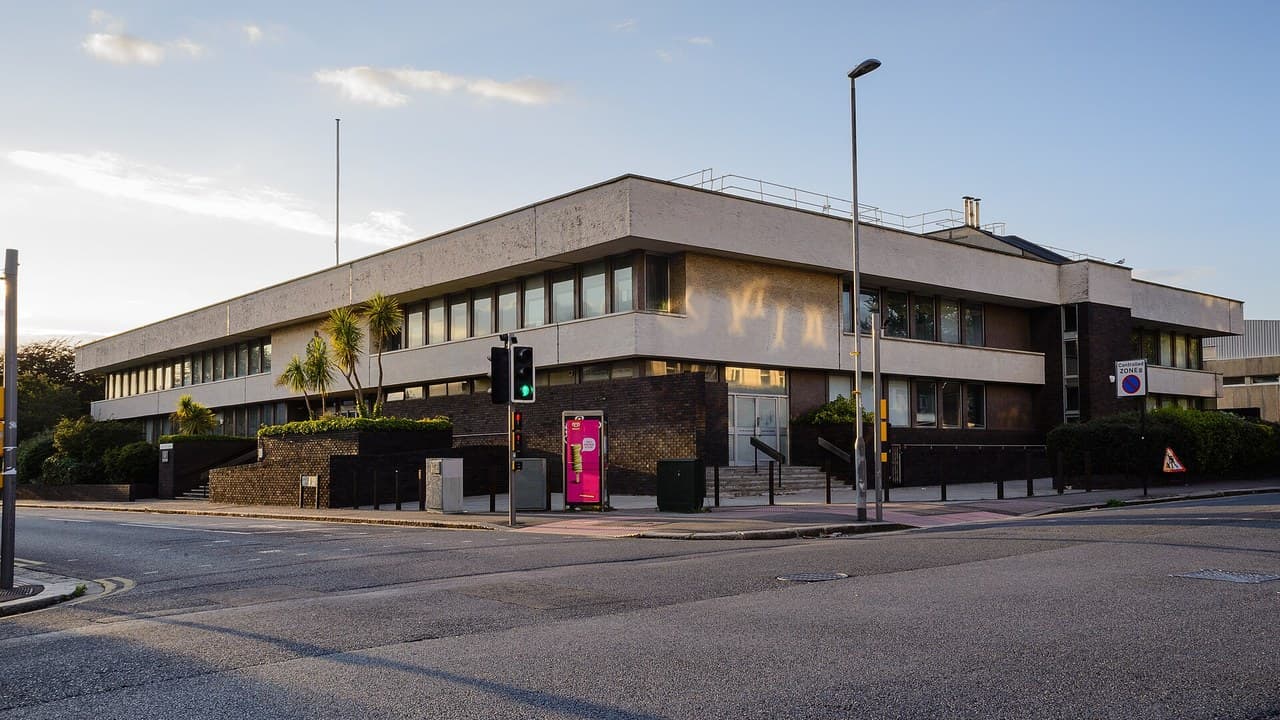 The concrete and brick Hove Trial Centre building at a street corner in evening light