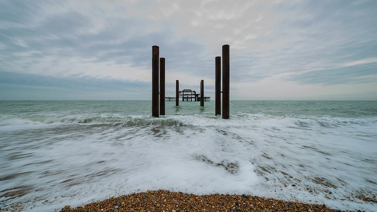 The remains of the West Pier at Brighton seen from the beach across breaking waves, with rusted iron columns in the foreground. File photo from March 2017.